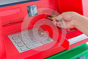 Hand insert credit card to ATM bank cash machine for withdraw mo