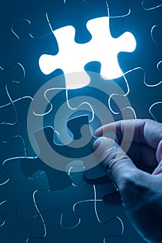 Hand insert jigsaw, conceptual image of business strategy