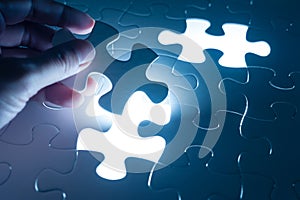 Hand insert jigsaw, conceptual image of business strategy