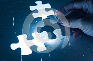 Hand insert jigsaw, conceptual image of business strategy photo