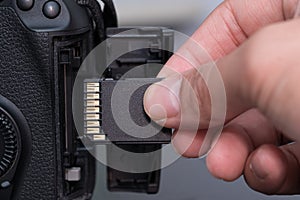 hand insert SD card in camera photo