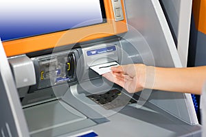 Hand inserting ATM card into bank machine for withdraw money