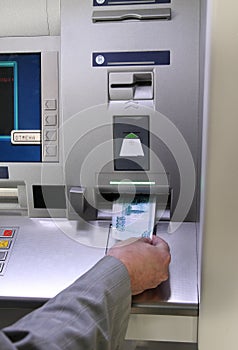 Hand inserting banknote into cash dispense