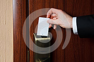 Hand inserting card into electronic lock in hotel