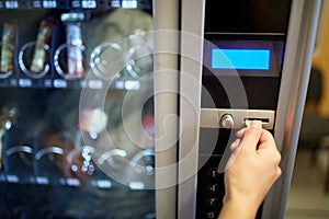 Hand inserting euro coin to vending machine slot