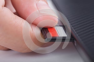 Hand inserting SD card into laptop