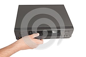 Hand inserts videocassette in videorecorder