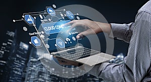 Hand interacting with futuristic laptop interface displaying cloud computing technology, data management, and digital