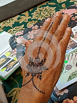 A hand with intricate henna designs, swirling patterns in reddish-brown, captivating work of art