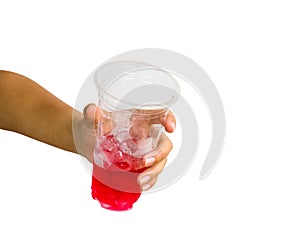 Hand isolated : A cropped female hand holding red sweet soda water in plastic glass giving on white background include clipping p