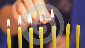 The hand of a Jewish woman lights candles at the Rosh of Ashana