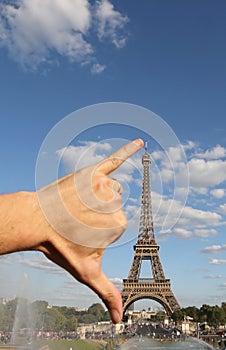 hand that jokingly measures the Eiffel Tower with the span