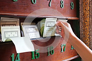 Hand keep fortune paper on shelf