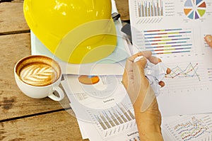 Hand keeping crumpled paper with document chart and coffee cups on work table backgrounds