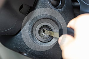 Hand on key inserted into switch of car