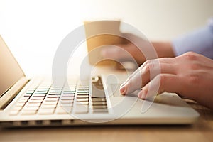 The hand on the keyboard and coffee