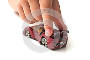 Hand of kid playng with miniature car