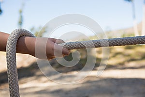 Hand of kid practicing tug of war during obstacle course