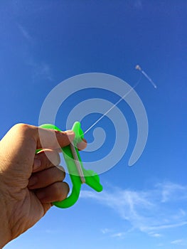 Hand with kite against sky