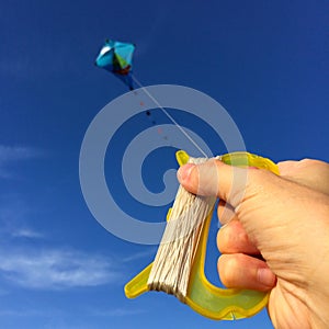 Hand with kite against sky