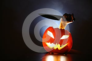 Hand with knife in Jack-o-lantern