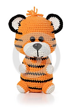 Hand knitted toy - small orange tiger on white background. Full depth of field.