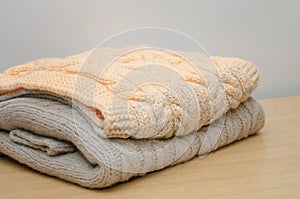 Hand-knitted warm folded clothes lie on the table. Handmade concept photo