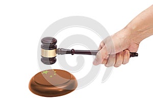 Hand knocking a Judge gavel at soundboard with China flag