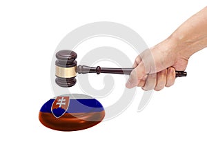 Hand knocking a Judge gavel at soundboard with Slovakia flag