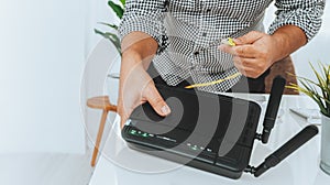 Hand and lan network cable with people work on wireless router, man working from home, while in quarantine isolation during the