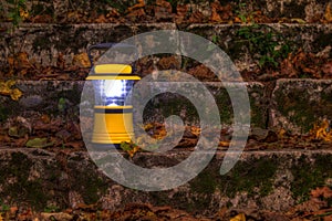 Hand lantern in stairs covered with dry leaves