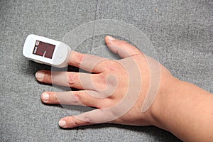 Hand of a Latin adult person with an oximeter on one finger to measure the oxygenation of a person with suspected covid-19 disease