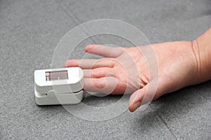 Hand of a Latin adult person with an oximeter on one finger to measure the oxygenation of a person with suspected covid-19 disease