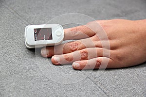 Hand of a Latin adult person with an oximeter on one finger to measure the oxygenation of a person with suspected covid-19 disease