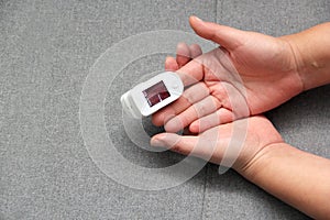 Hand of a Latin adult person with an oximeter on one finger to measure the oxygenation of a person with suspected covid-19 disease