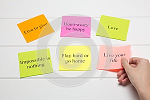 The hand lays out motivational cards. Color sheets with quotes. Visualization Board, self-discipline, development, training. Flat