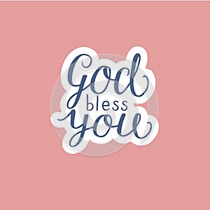 Hand lettering God bless you made on pink background.