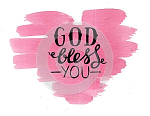 Hand lettering God bless you, made on pink watercolor heart.