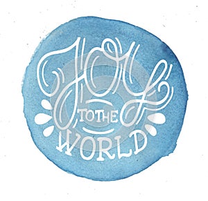 Hand lettering Joy to the world on blue watercolor background.