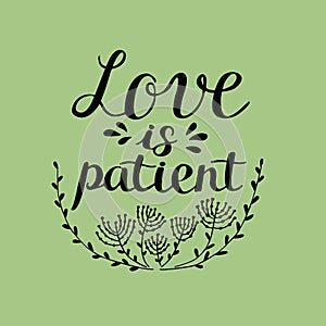 Hand lettering Love is patient, made near flowers.