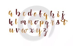 Hand lettering, modern calligraphy alphabet in autumnal colors brown and gold on a white paper, handwritten