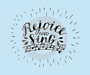 Hand lettering Rejoice and sing, made on blue background with notes.