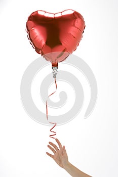 Hand Letting Go Of Heart Shaped Balloon