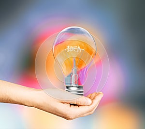 Hand with light bulb and the word idea