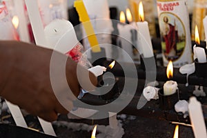 A hand lighting a candle