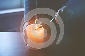 Hand lighting candle