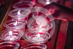 Hand Lighting up prayer candles inside a church in Vienna, Austria