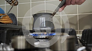 Hand lights up a gas stove and puts Turkish coffee warmer on it, low angle shot.