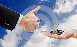 Hand like and hand with seed and coins over cloud background