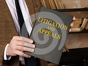 Hand with litigation and appeals rules book.